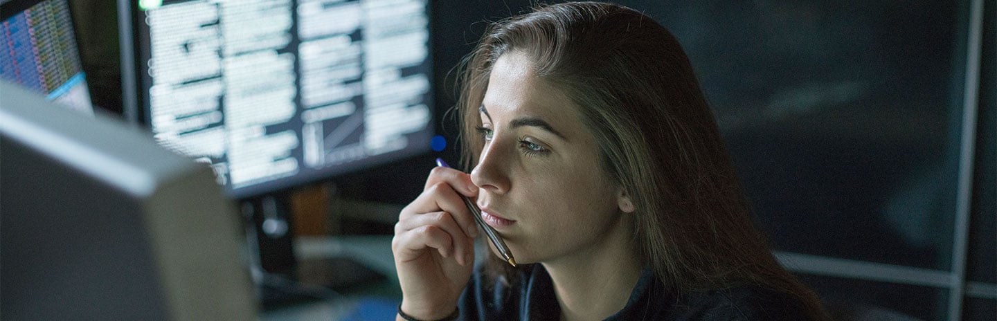 Girl in dark office looking at data